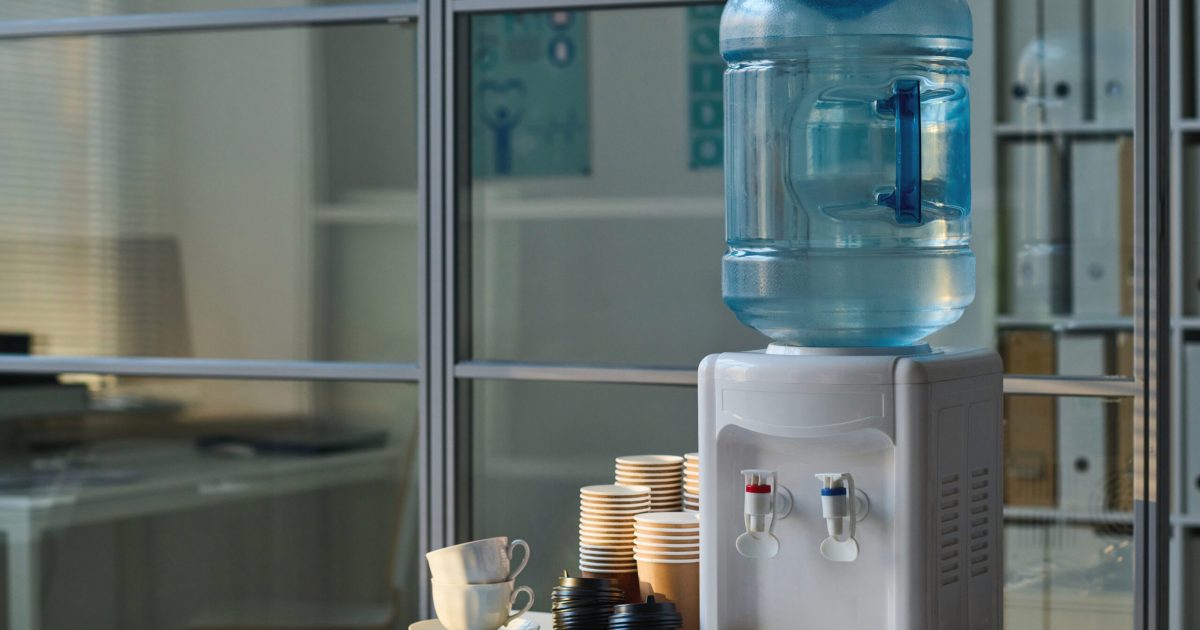 Place for coffee break in office with water and cups on table in modern office