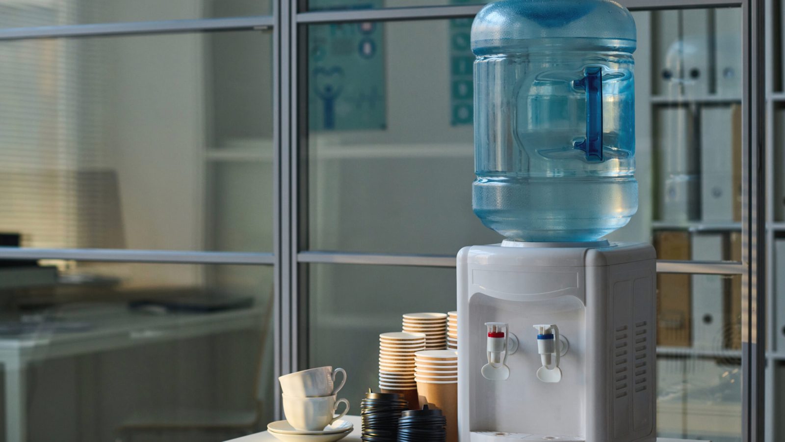 Place for coffee break in office with water and cups on table in modern office